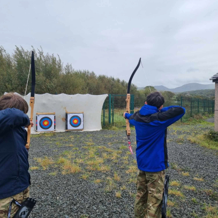 Shows a kayak, tent, rucksack and camping equipment